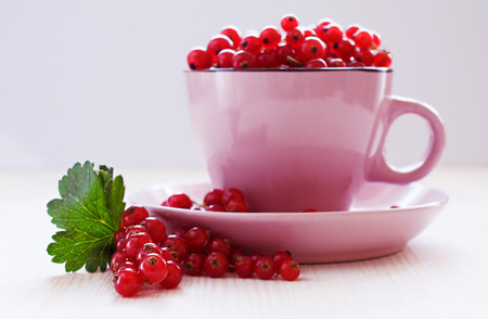 Ripe red currants in a pink cupの写真素材