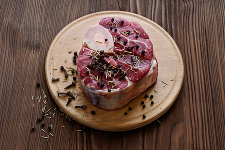 Raw beef steak  with a spices on a dark wooden tableの写真素材