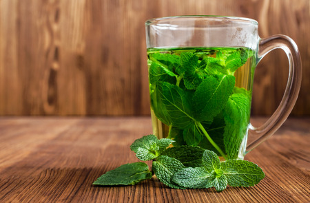 Mint tea in a glass cup on woodenの写真素材