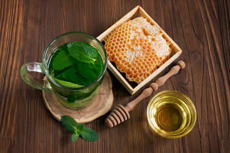 Honeycomb and mint tea on woodenの写真素材