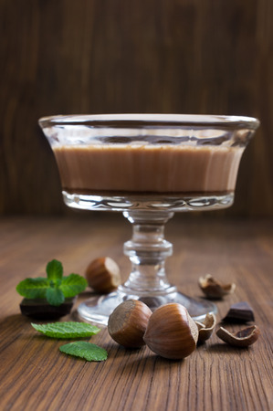 Chocolate mousse dessert with mint and hazelnuts on woodenの写真素材