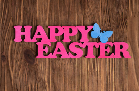Pink words "Happy Easter" on a wooden backgroundの写真素材