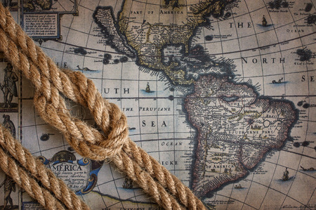 Rope with marine knot lies against the backdrop of an old mapの写真素材