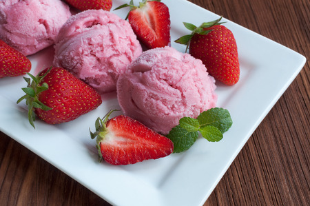 Scoops of strawberry ice cream close up and fresh berriesの写真素材