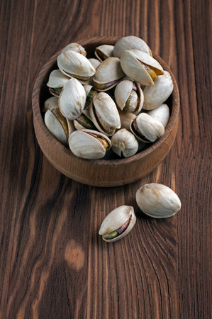 Pistachios in a wooden bowl. Food in a rustic style.の写真素材