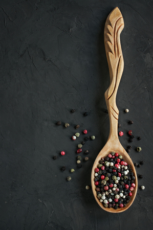 Wooden spoon with mix of peppers on a dark backgroundの写真素材