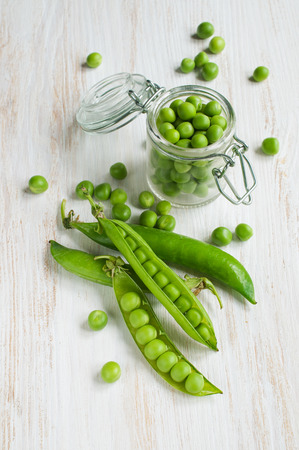 Fresh young green peas on white wooden tableの写真素材