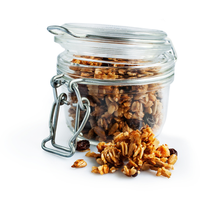 Homemade granola  in a glass jar isolated on a white backgroundの写真素材