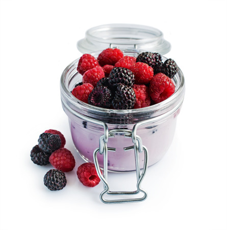 Yogurt with red and black raspberries isolated on whiteの写真素材