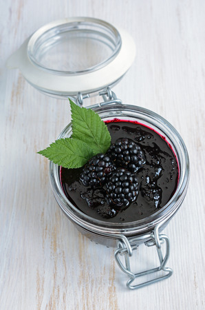 Homemade blackberry jam in a glass jar with fresh berriesの写真素材