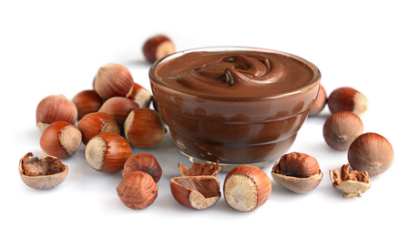 Homemade hazelnut spread in glass bowl with nuts isolated on a whiteの写真素材