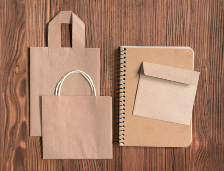 Mock up with craft bag, sketchbooks and envelope on wooden background, top view.の写真素材