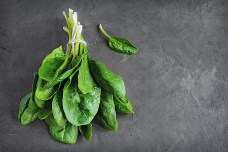 Bunch of fresh spinach on black backgroundの写真素材