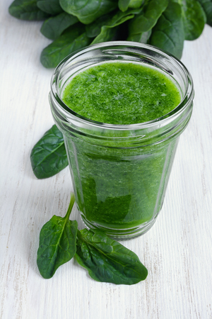 Green smoothie of fresh spinach on wooden table. Healthy food.の写真素材