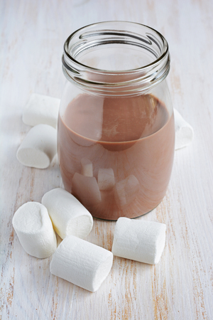 Chocolate milk with marshmallow on white wooden tableの写真素材