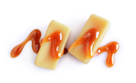 Caramel candies and liquid caramel isolated on white backgroundの写真素材