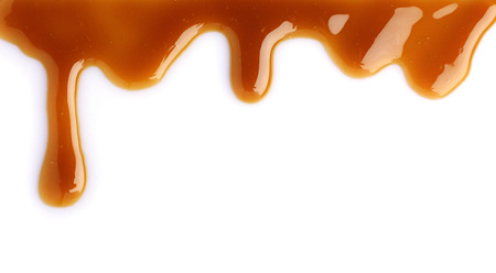 Melted caramel dripping isolated on white backgroundの写真素材