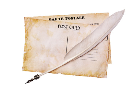 Old grunge postal cards and feather pen isolated on whiteの写真素材