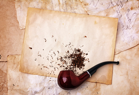 Smoking pipe and tobacco on old paper textureの写真素材