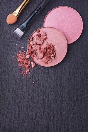 Pink and beige blush on black slate backgroundの写真素材