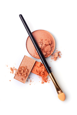 Beige and orange crushed eyeshadow and makeup brush isolated on white backgroundの写真素材