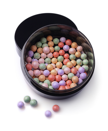 Varicoloured blush balls in black container isolated on white backgroundの写真素材