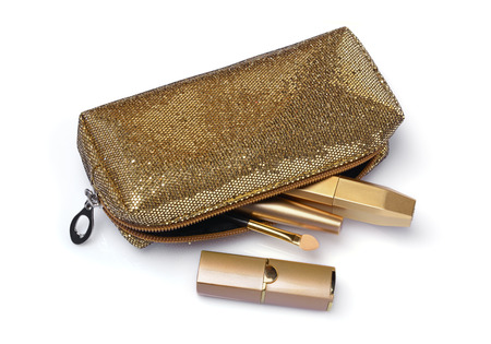 Composition of cosmetics in golden case with golden cosmetic bag isolated on whiteの写真素材