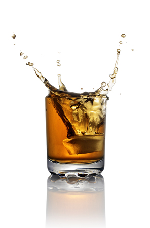 Splash in glass of scotch whiskey with ice cubes isolated on white backgroundの写真素材