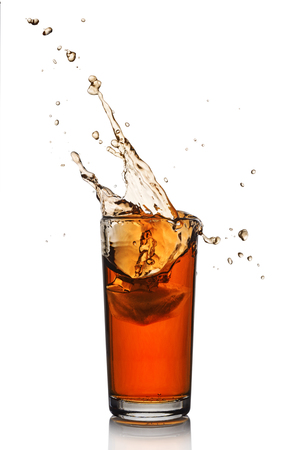 Splash in glass of black tea with ice isolated on white backgroundの写真素材