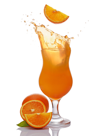 Splash in glass of alcoholic tropical cocktail drink with falling slice of orange isolated on white backgroundの写真素材