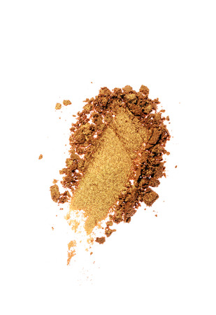 Smear of crushed golden eyeshadow as sample of cosmetic product isolated on white backgroundの写真素材