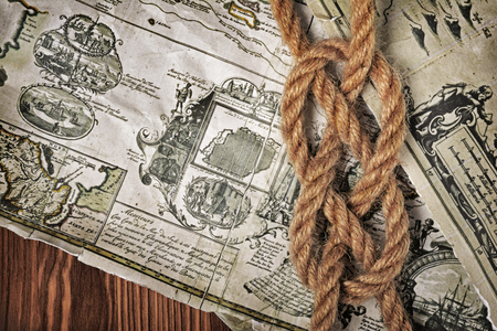 Close-up view of a rope sea knot on an old retro map. The map used for background is in Public...