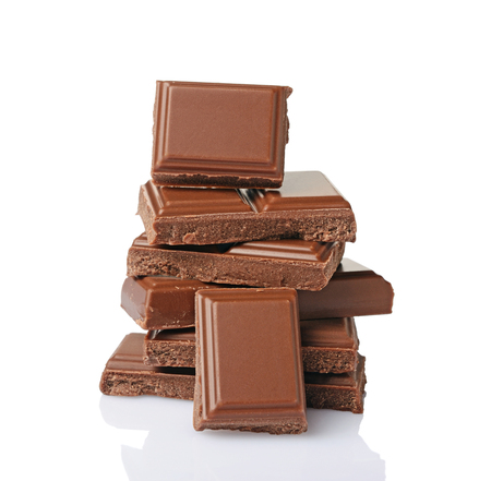 Close-up pieces of milk chocolate bar isolated on white backgroundの写真素材