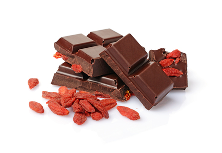 Close-up pieces of dark chocolate bar with dried Goji berries isolated on white backgroundの写真素材
