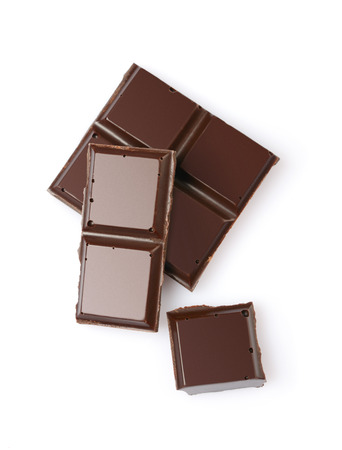 Close-up pieces of dark chocolate bar isolated on white backgroundの写真素材