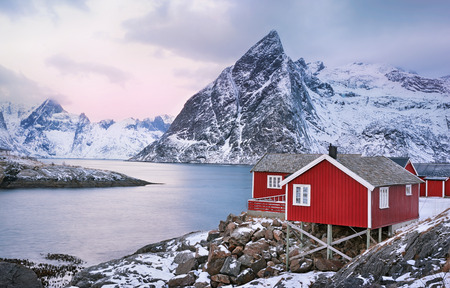 Beautiful sunrise landscape with traditional Norwegian fishing huts in the mountains of Lofoten islands in Norwegian Sea, Norwayの写真素材