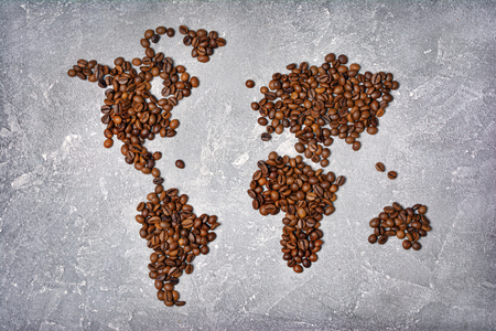 Symbolic image of world map made from roasted coffee beans on gray concrete backgroundの写真素材