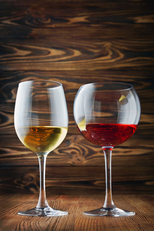 Couple glasses with red and white wine for tasting on wood texture backgroundの写真素材