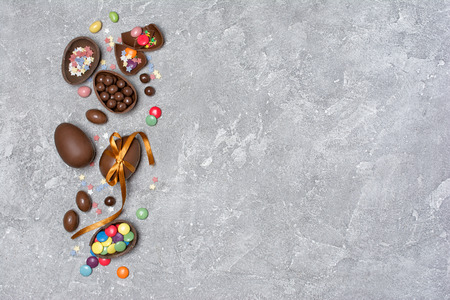 Top view on chocolate traditional easter eggs with bright colorful dragee and sugar sprinkles or...