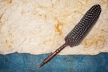 Mockup of empty old vintage yellowed paper sheet with luxury quill pen on blue concrete backgroundの写真素材