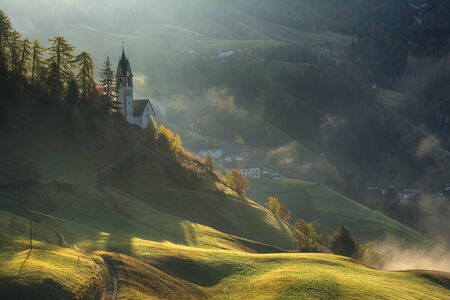 Picturesque landscape of foggy morning in La Valle Wengen mountain village in Dolomites Alpsの写真素材