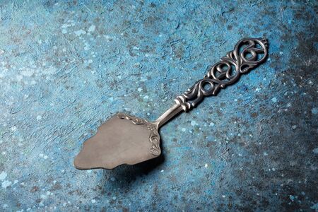 Top view of vintage silver cutlery or silverware on blue concrete backgroundの写真素材