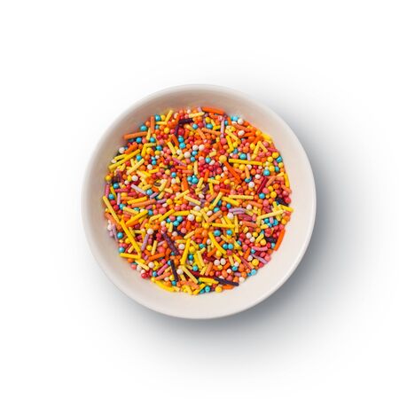 Top view of multicolored sugar sprinkles or confetti in bowl isolated on white backgroundの写真素材