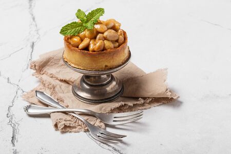 Tasty nutty dessert on vintage silver tray with fresh green mint on white marble backgroundの写真素材