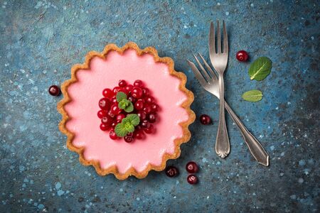Top view of tasty berry dessert with vintage silver cutlery and fresh green mint on blue concrete backgroundの写真素材