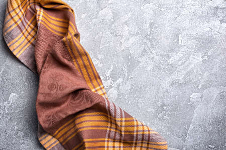 Top view of brown folded kitchen towel or serviette on grey concrete backgroundの写真素材