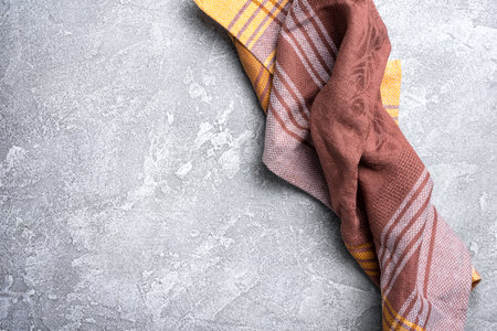 Top view of brown folded kitchen towel or serviette on grey concrete backgroundの写真素材