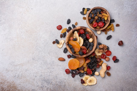 Top view of wooden bowls with dried fruit, berries and nuts as ingredient for tasty and healthy meal...