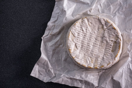 Top view of white brie cheese or camembert, tasty meal for baking on black concrete backgroundの写真素材