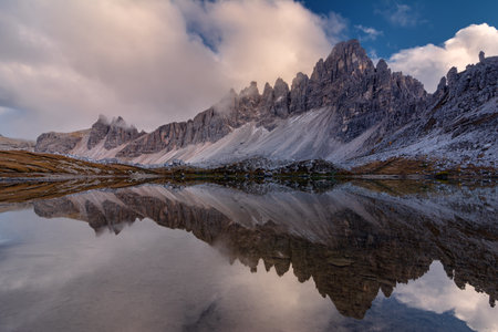 Picturesque landscape of beautiful mountain lake in Tre cime di lavaredo, Dolomites Alps on blue cloudy sky backgroundの写真素材
